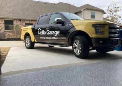 A black and yellow truck parked in front of a house.