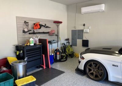 A garage with a white car and tools.